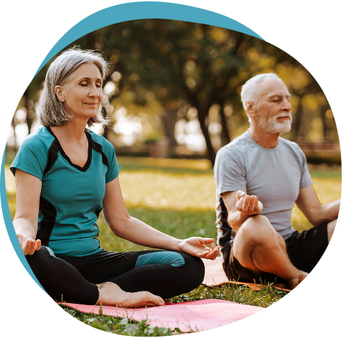 Man and woman meditating outdoors in a park
