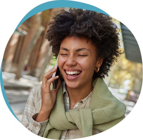 Woman laughing while talking on the phone outdoors